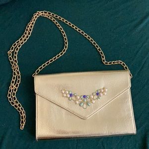 Gold purse with gold chain and blue/white appliqué
